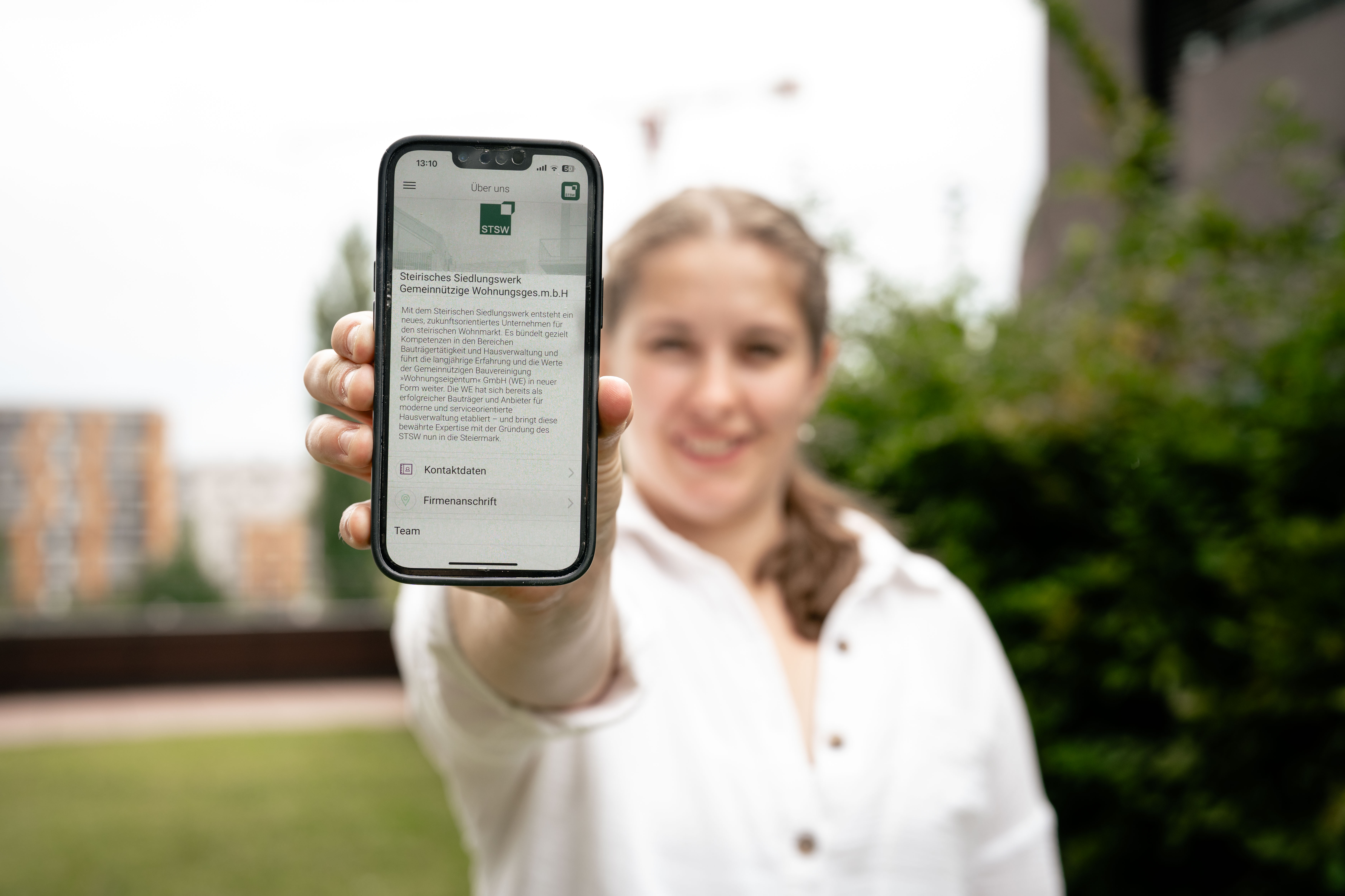 Frau hält Smartphone mit STSW App
